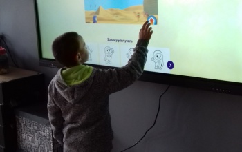 Powiększ obraz: uczeń korzysta z tablicy interaktywnej na świetlicy szkolnej