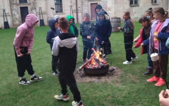 Powiększ obraz: uczniowie pieką kiełbaski nad ogniskiem
